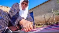 Evinin bahçesindeki tezgahta asırlık yöntemle kilim dokuyor