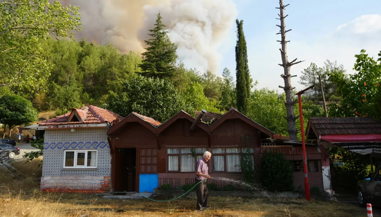 Elinde hortumla otları ıslatarak evini yangından korumaya çalıştı