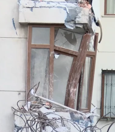 Kepçe darbesiyle yıkılan duvar yan binanın üzerine devrildi