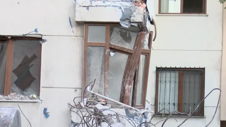 Kepçe darbesiyle yıkılan duvar yan binanın üzerine devrildi